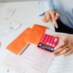 An accountant at a desk with papers and a calculator.