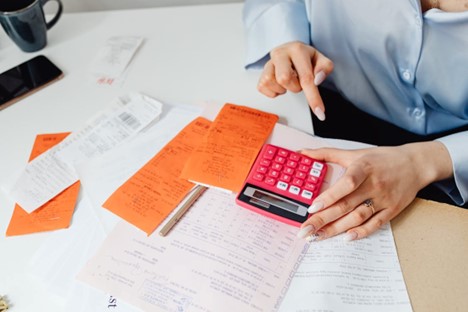 An accountant at a desk with papers and a calculator.