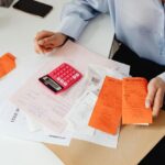 A bookkeeper handling receipts in front of a calculator