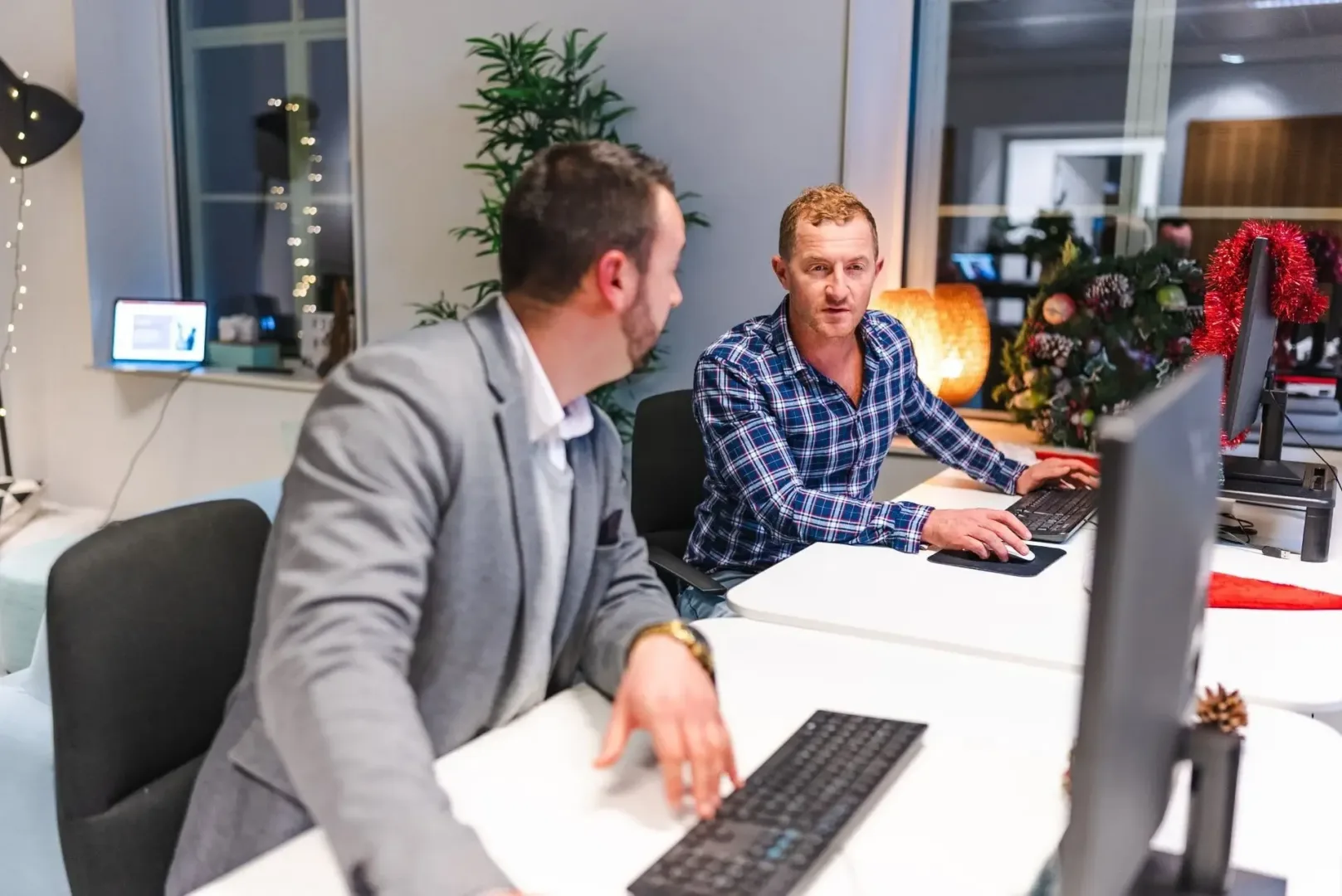 men collaborating in front of computers in an office.